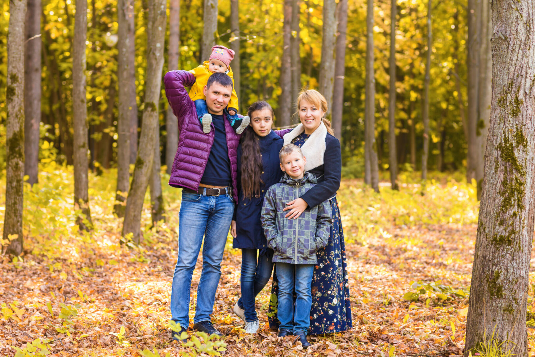 Family Group Relaxing Outdoors In Autumn Landscape