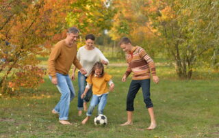 Portrait Of Big Happy Family Playing Football In Park