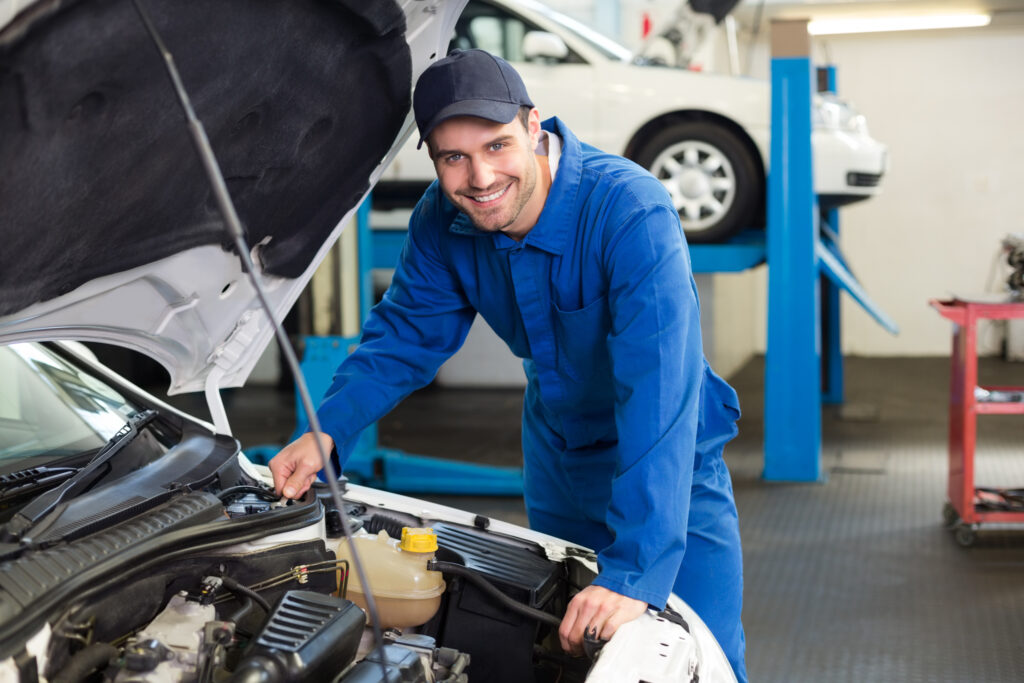 Mechanic Examining Under Hood Of Car At The Repair Garage