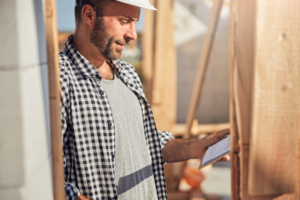 Qualified Field Engineer Checking His Plan At Construction Site