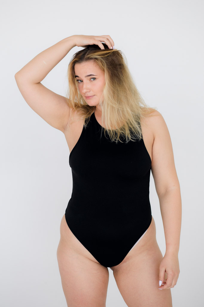 Beautiful Overweight Woman In Black Swimsuit On Grey Background