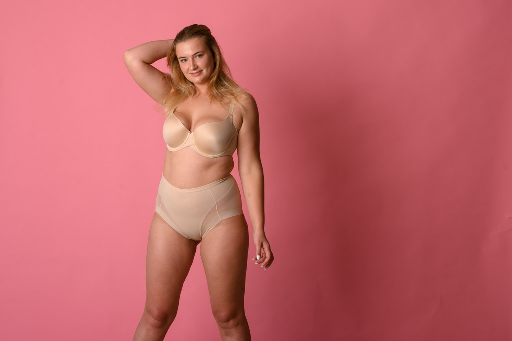 Beautiful Overweight Woman In Beige Swimsuit On Pink Background